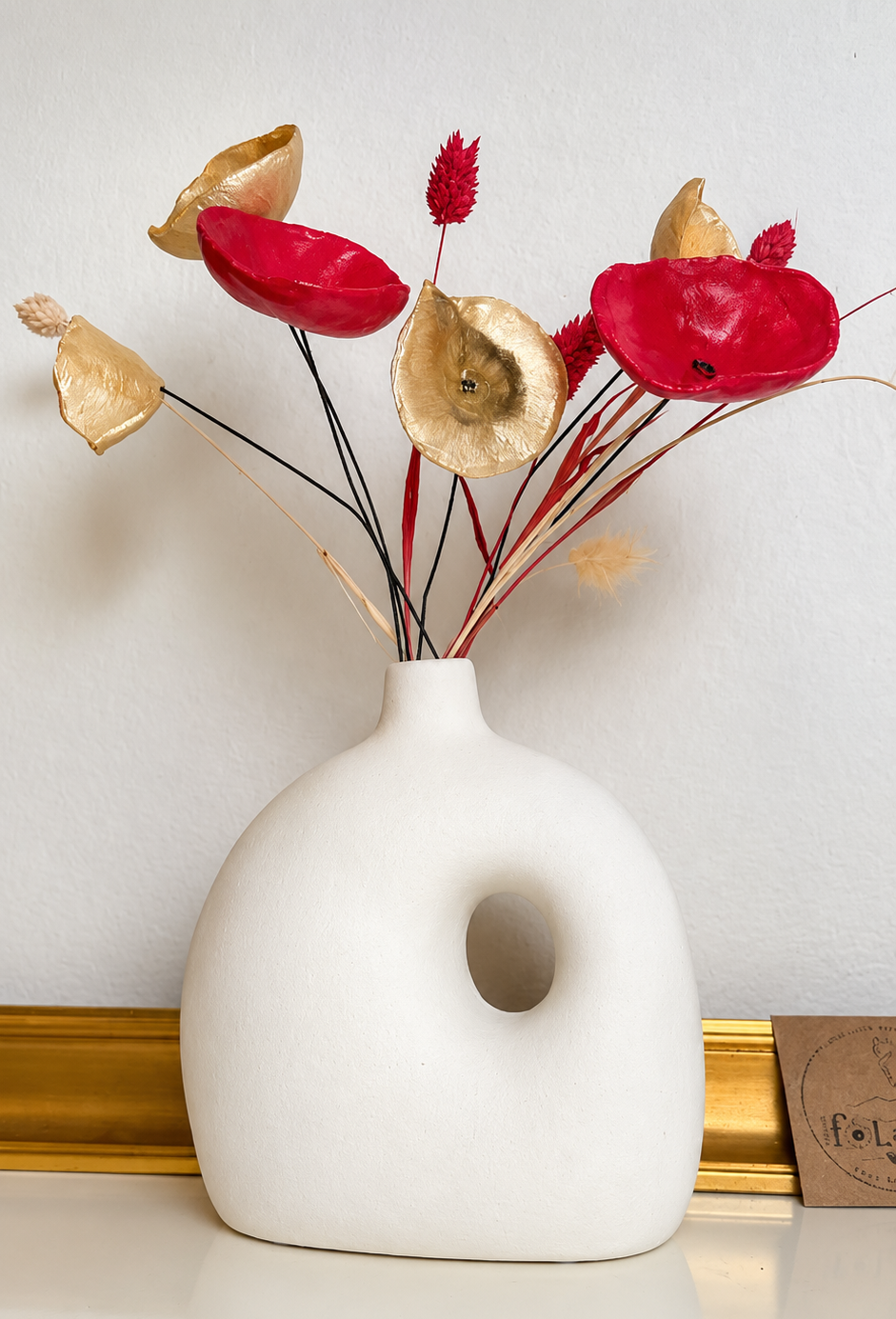 Composition florale de Noël : fleurs fOLavriL en argile dorées et rouges et fleurs séchées dans vase en ceramique
