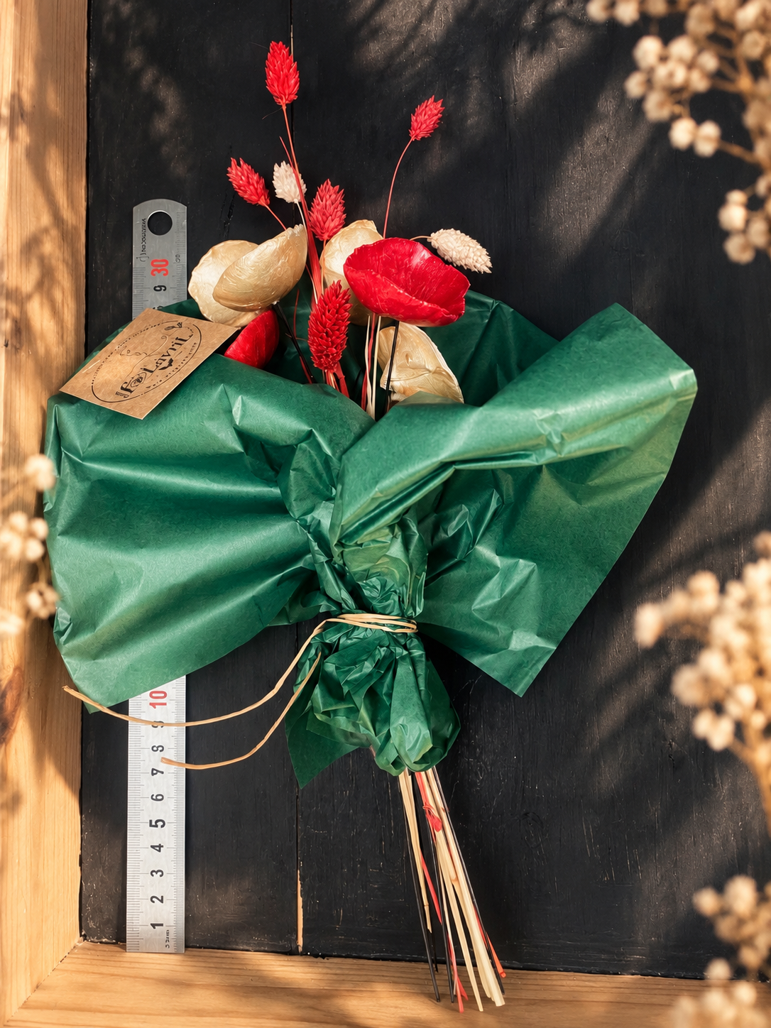 Composition florale de Noël : fleurs fOLavriL en argile dorées et rouges et fleurs séchées dans vase en ceramique